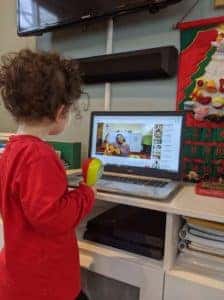 Photo of a young child watching a pre-recorded Telehealth music therapy session created by AMT's music therapist Anissa
