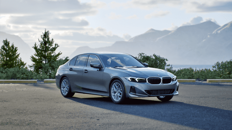 A metallic silver 2026 BMW 3 Series sedan parked on a scenic mountain overlook.