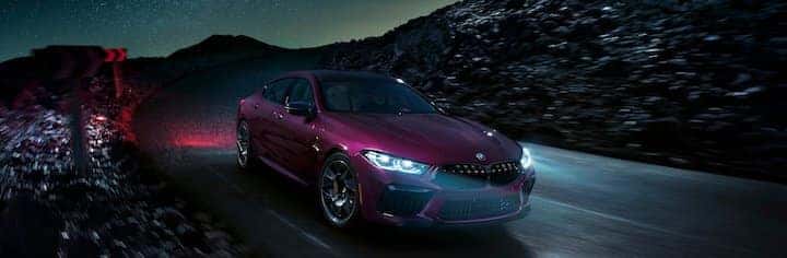 BMW M8 Gran Coupe in purple driving at night