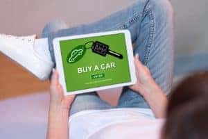 A close up of someone buying a car online with a tablet at BMW of Stratham.